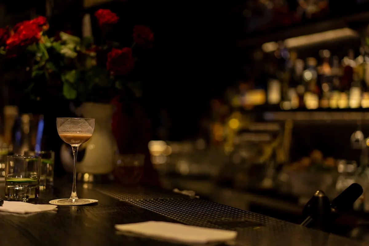 A drink resting on the bar as the evening settles in
