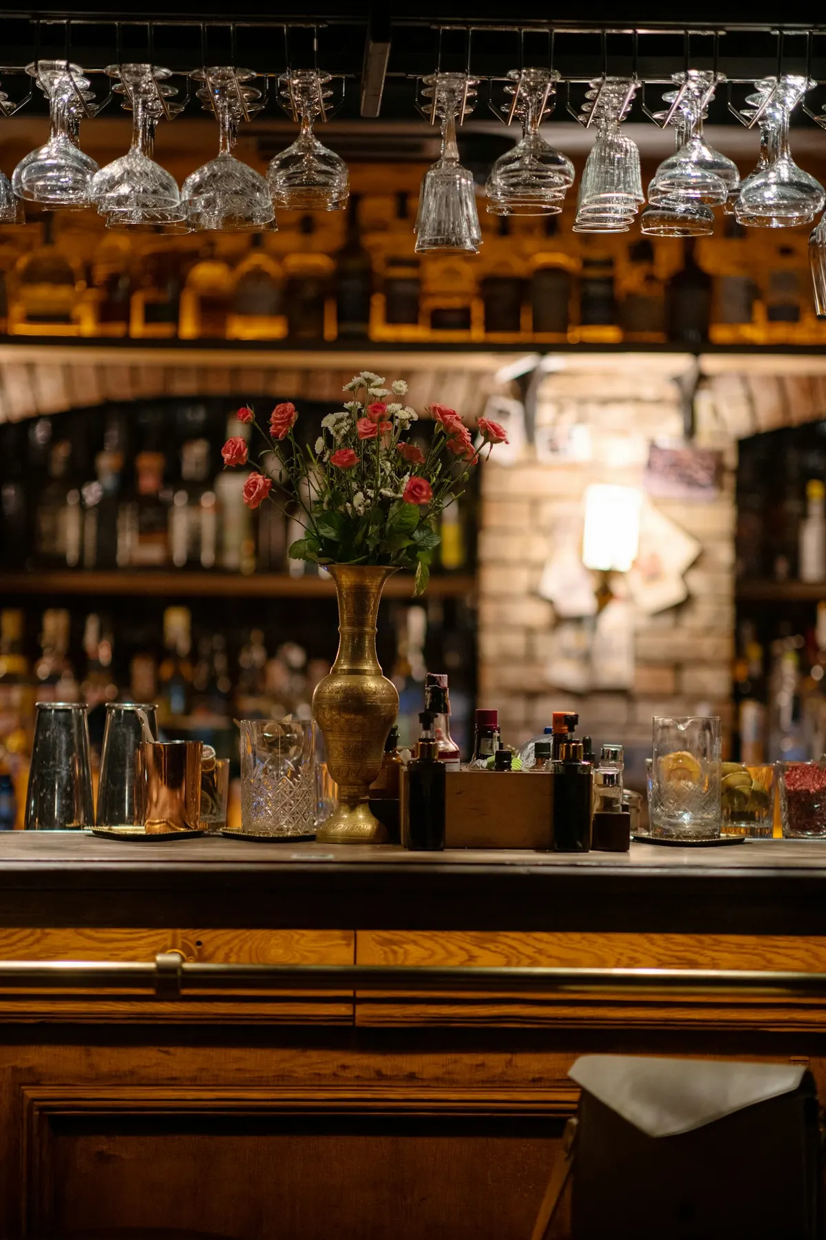 Polished glassware hanging above a quiet bar counter