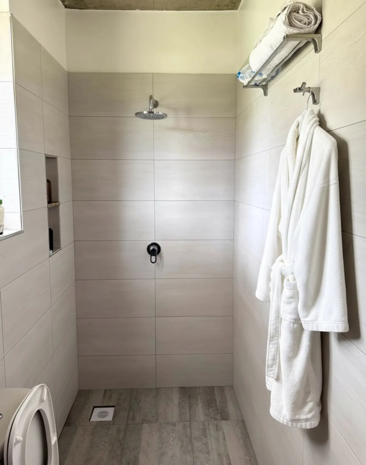A private bathroom with a rainfall shower and fresh robes