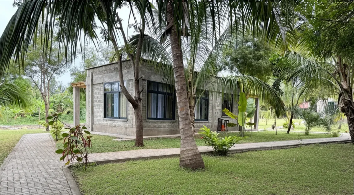 A garden room along a stone footpath, framed by palms