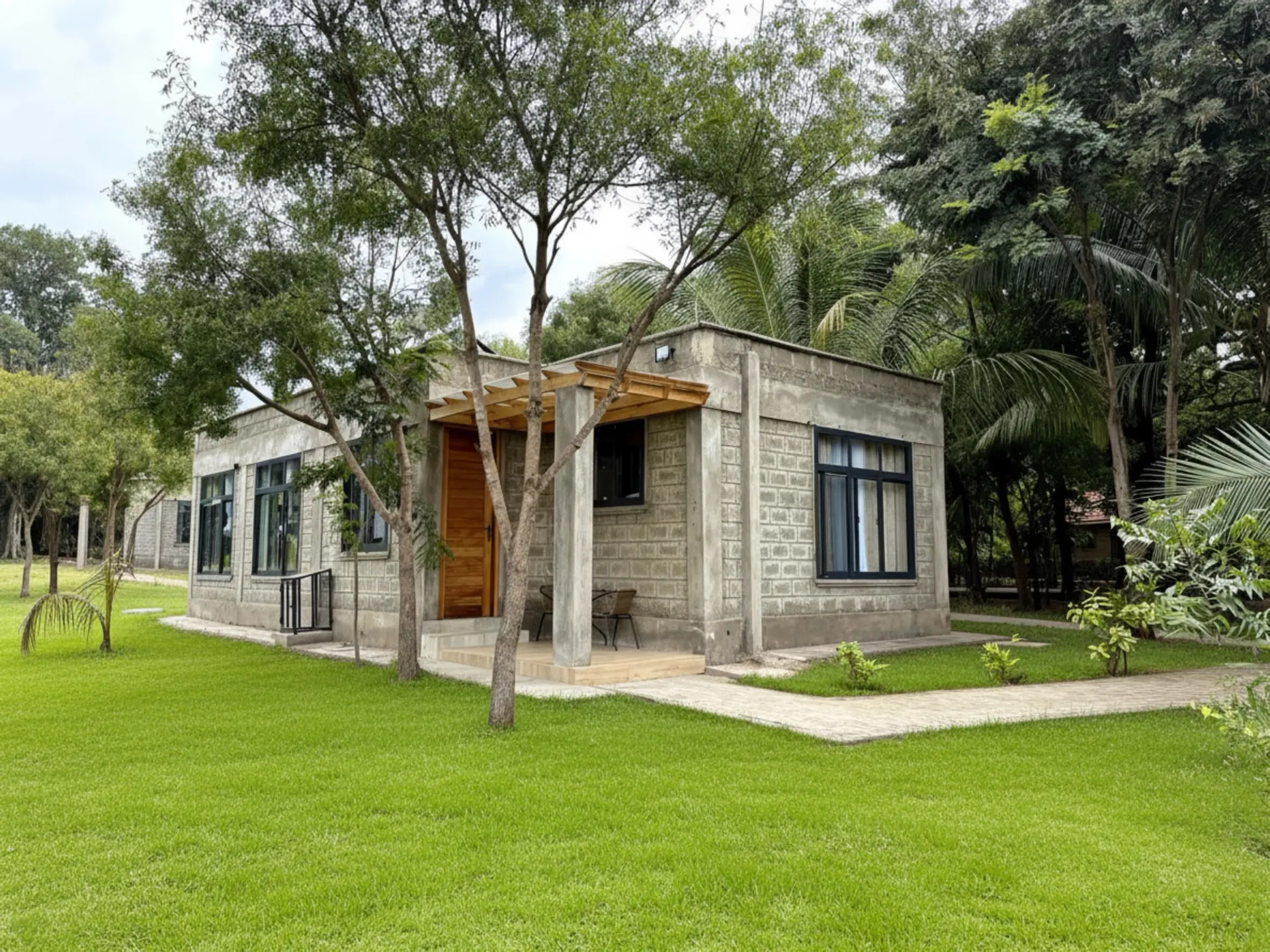 A Nagira garden cottage framed by lawn and palms